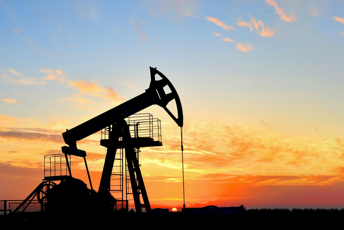 Oil-drilling derricks are shown at a desert oil field. 